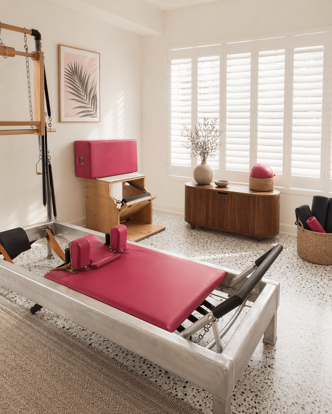 Private Pilates home studio with raspberry reformer and white shutters